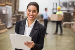 36390661 - smiling warehouse manager writing on clipboard in warehouse